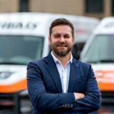 Connor Green in front of company vehicles